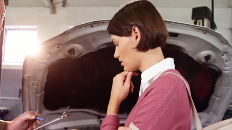 Worried-woman-interacting-with-mechanic