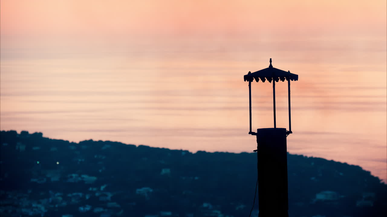 Aerial view a lighthouse with the Eze seaside commune in the Alpes-Maritimes at sunset on the background