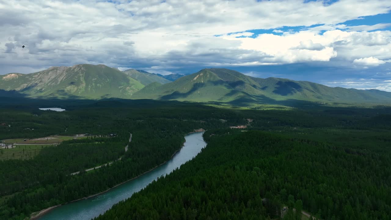 몬타나의 배경에 능선이 있는 납작한 강 숲이 우거진 숲