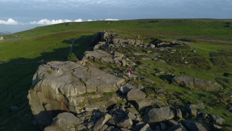 Drone-Shot-Flying-Over-Cow-and-Calf-Rocks-with-People-Walking-on-Ilkley-Moor-West-Yorkshire-UK