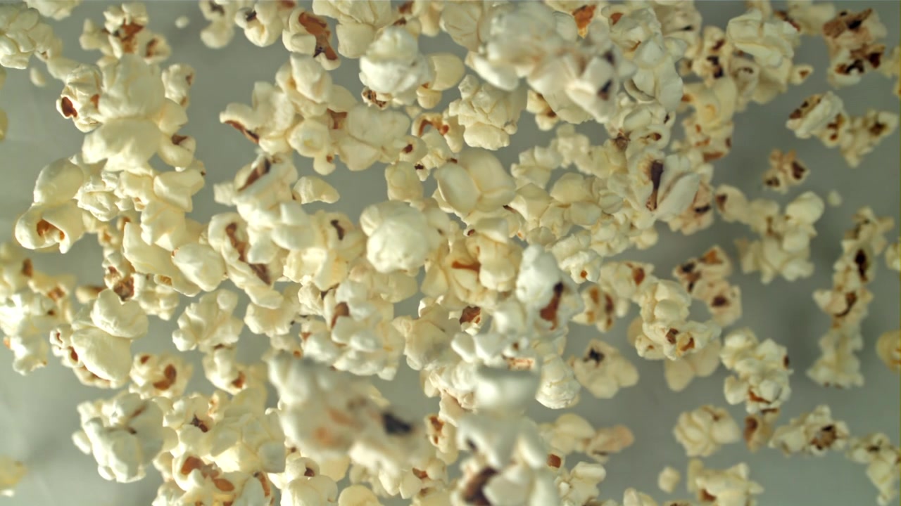 Delicious Popcorn Falling in Slow Motion on White Background