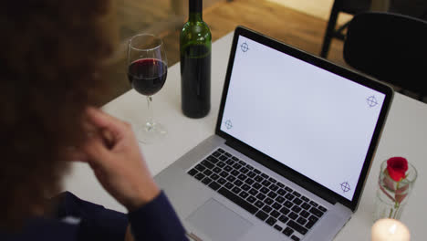 mujer caucásica teniendo una cena romántica en video chat usando portátil con espacio de copia