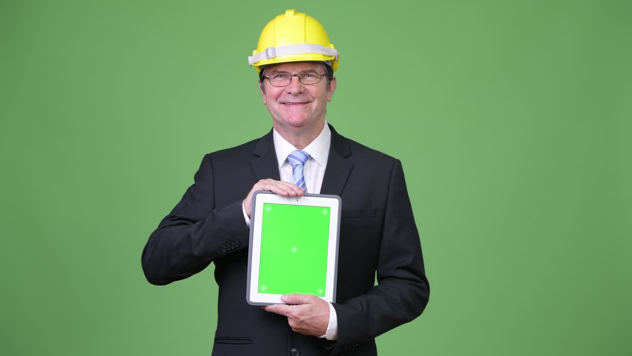 un hombre de negocios guapo como ingeniero mostrando una tableta digital.