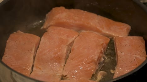 cooking slices of salmon fillet in a frying pan