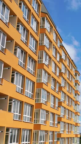 cropped view of the modern apartment buildings exteriors. contemporary residential orange and white buildings with outdoor facilities vertical video
