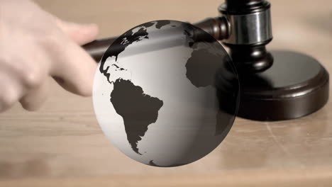 animation of spinning globe over hand using gavel