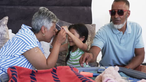 Una-Niña-Birracial-Juega-Al-Escondite-Con-Una-Mujer-Birracial,-Mientras-Un-Hombre-Birracial-Observa