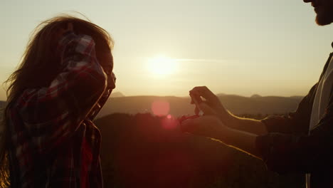 man proposing marriage to woman during hike