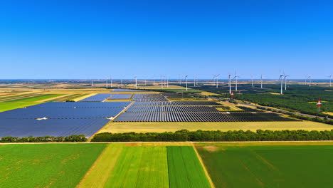 green energy is produced in the countryside. drone flight over the fields with solar panels and wind turbines