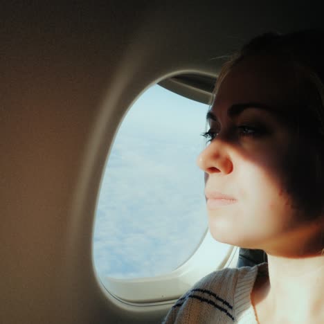 A-Female-Passenger-Looks-Out-The-Window-Of-The-Plane-To-The-City-Below-1