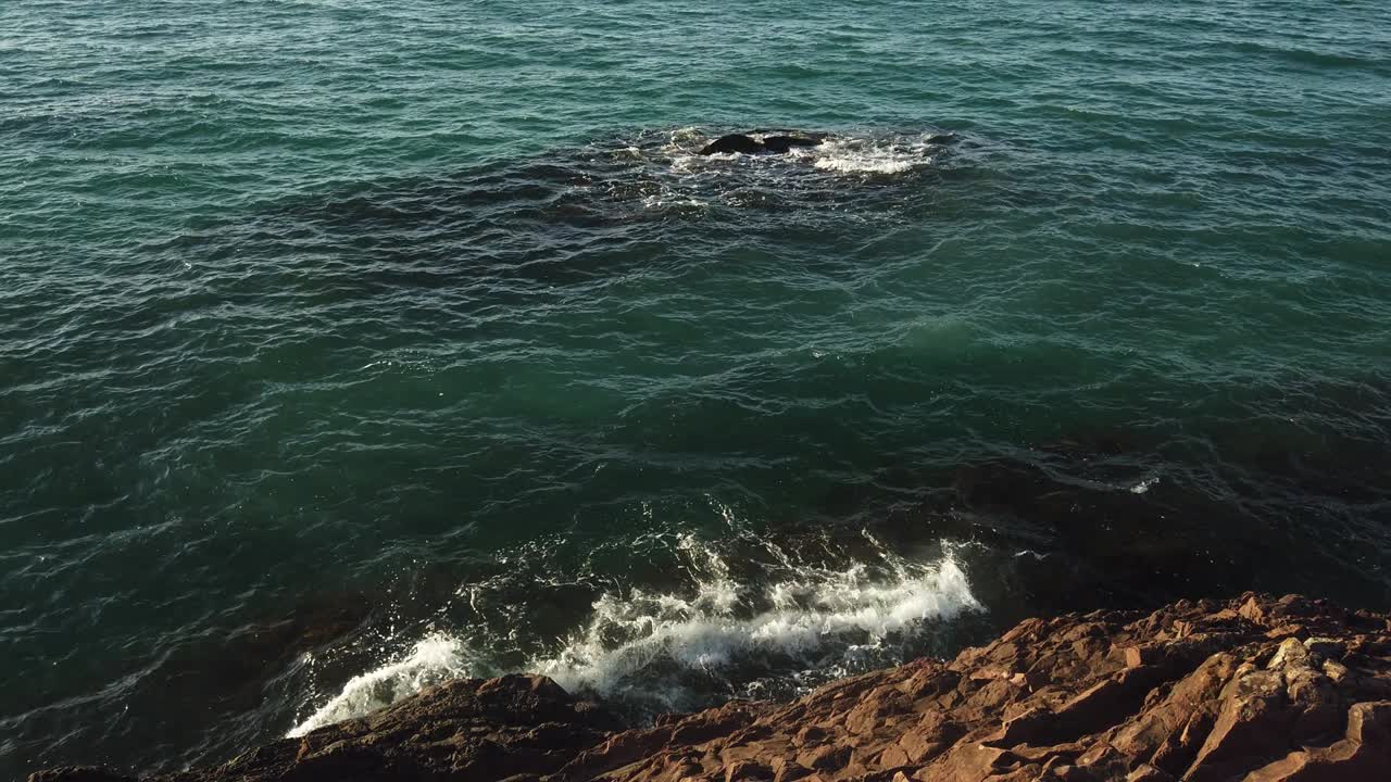 vista aérea de los pájaros mirando hacia abajo a las olas del mar que se estrellan. verde y azul vista superior del mar drone, imágenes de drones, 4k