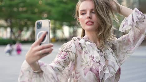 una mujer tomando una selfie en una ciudad.