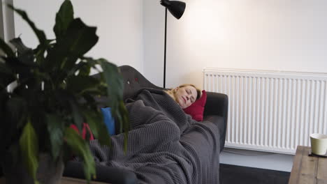 woman sleeping on couch with blanket