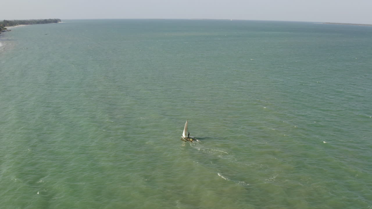 рыбацкая лодка плывет по песчаному пляжу у побережья города дар-эс-салам, танзания