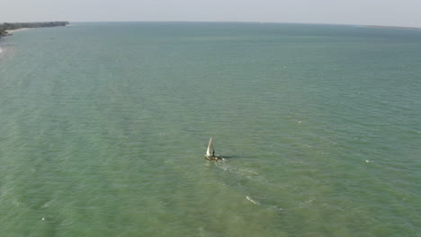 barco de pesca navegando cerca de la costa de la playa de arena de la ciudad de dar es salaam, tanzania