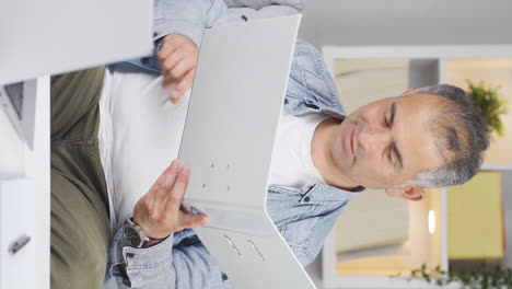 vertical video of the man examining the files approves the files with his head.