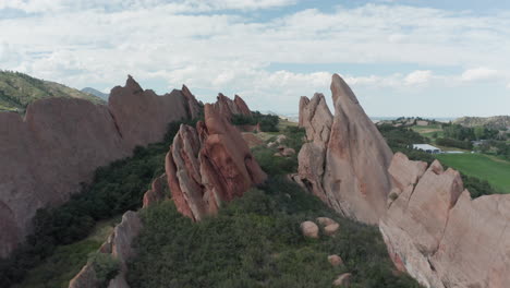 campo de golf de punta de flecha en littleton colorado con césped verde, rocas rojas y cielos azules