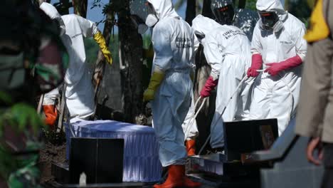 the group of covid-19 officers in indonesia is burying the bodies of those who have been confirmed by the corona virus