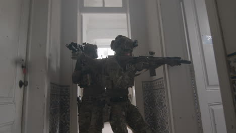 group of men in camouflage uniform and rifles playing airsoft indoor