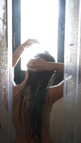 mujer lavándose el cabello en la ducha