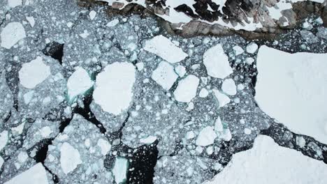 breaking ice near coast of greenland, aerial drone view