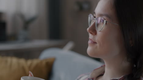 woman drinking coffee or tea on sofa