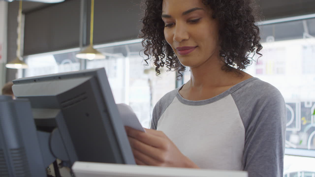 Waitress Adding Up Bill At Cash Register In Coffee Shop