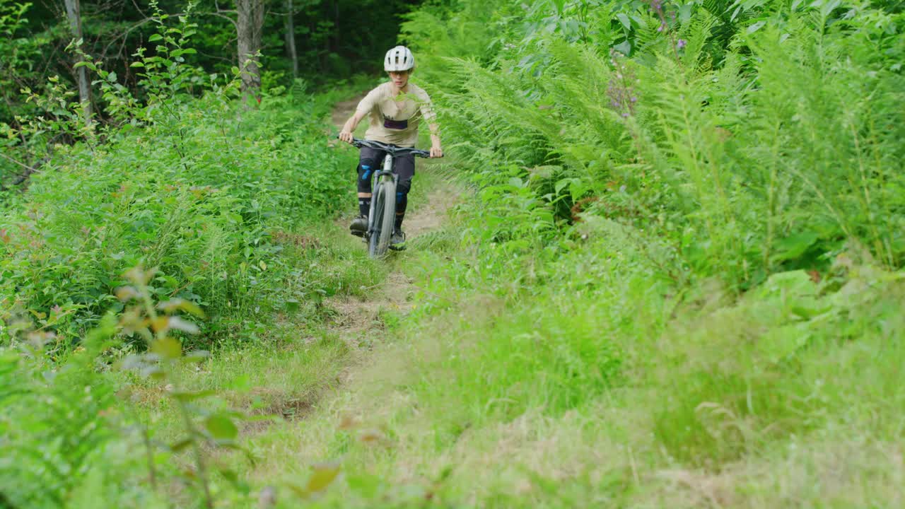 un ciclista de montaña recorre un sendero en un día cálido en cámara lenta