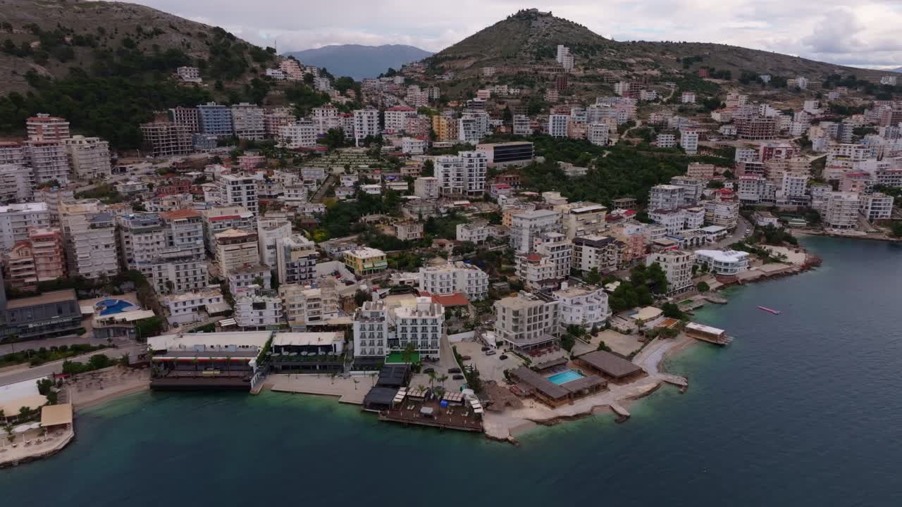 Captura aérea da cênica costa de Saranda com edifícios na encosta, Albânia