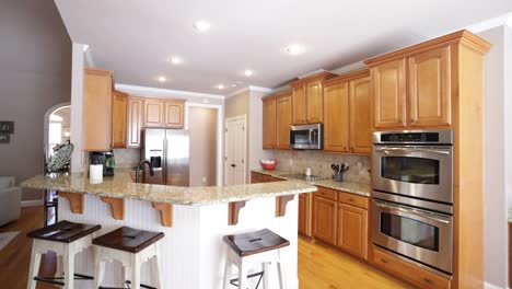 large brown u-shaped kitchen with wood cabinets and marble countertop