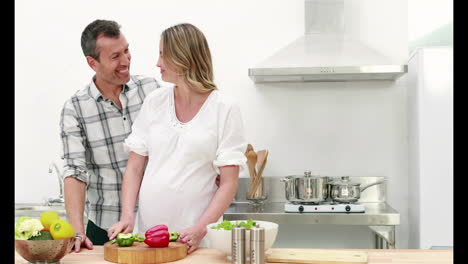 mujer embarazada haciendo una ensalada con su marido