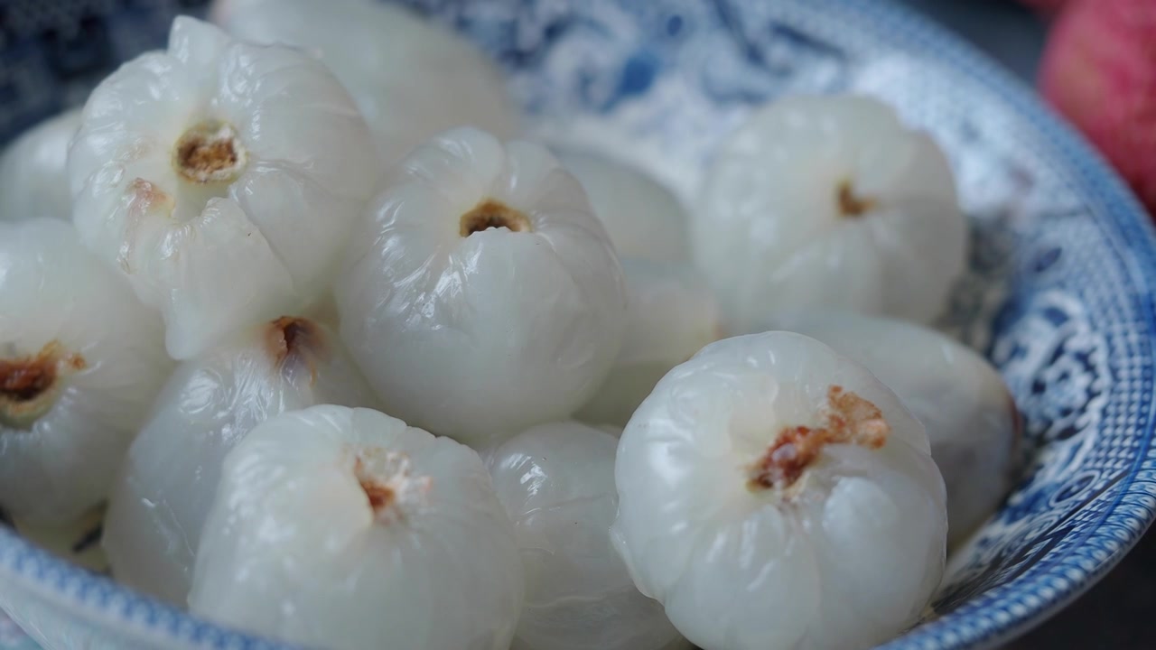 Vải thiều đã bóc vỏ trong bát gốm sứ xanh trắng trang trí