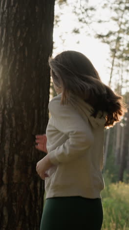 woman sprints in woods at sunset. female athlete takes active run among trees engaging in cardio exercises to improve physical health. evening workout