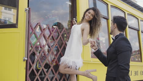 couple holding hands on a yellow tram