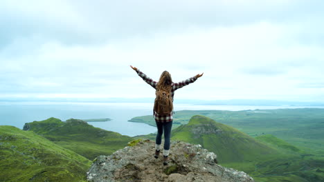 woman enjoying a view from a mountain summit