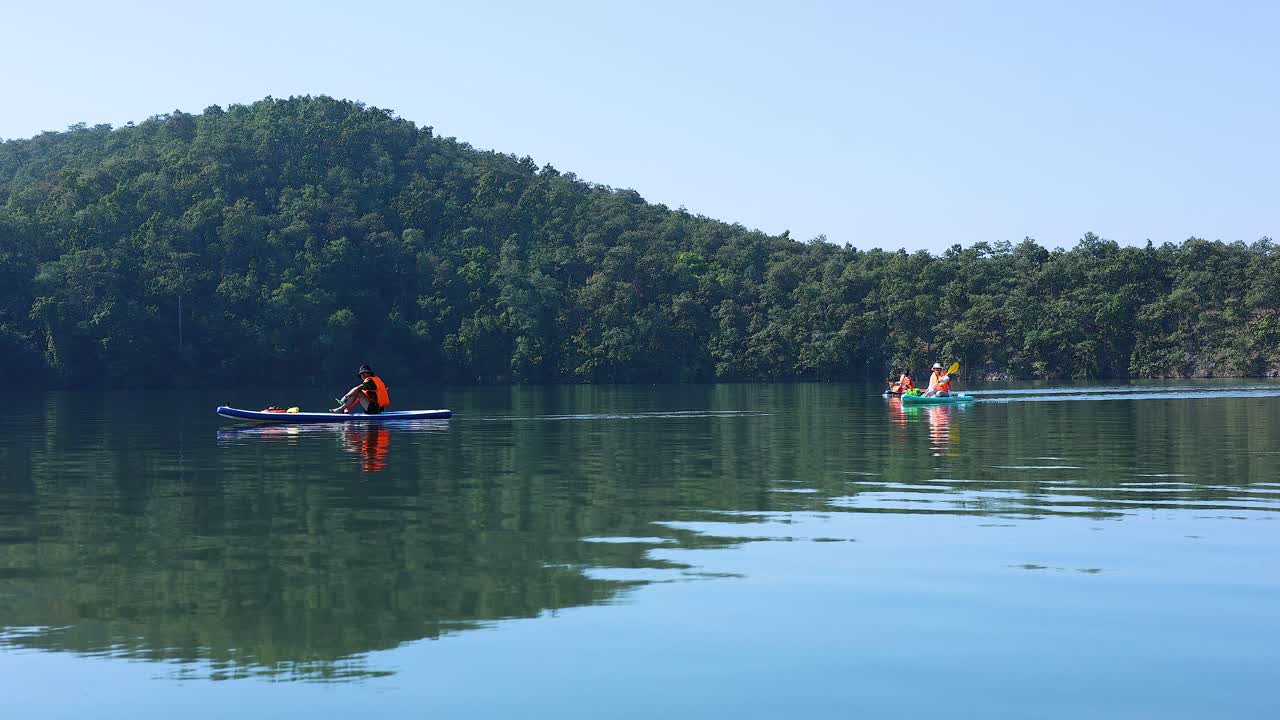 Group of kayakers paddling in calm waters