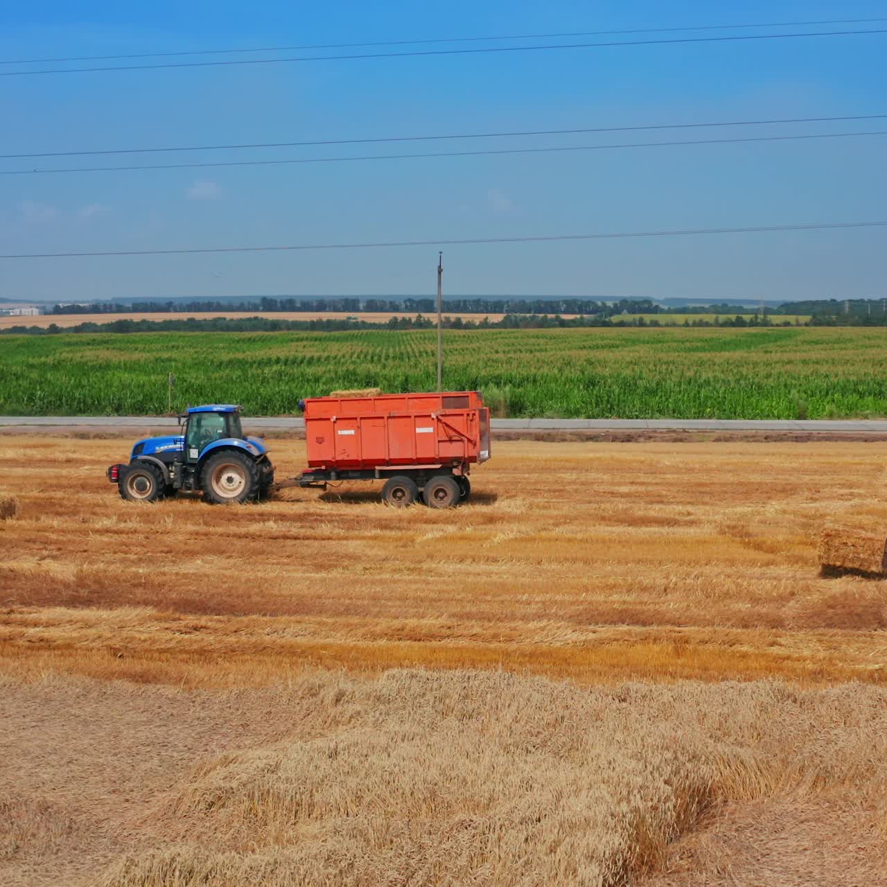 Agricultural summer farming field. Aerial view of tractor working in the field
