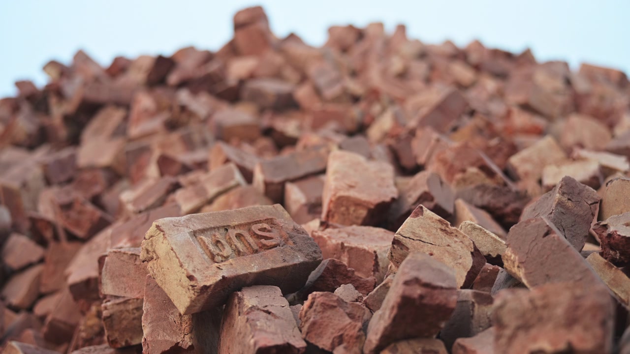 Shallow depth of field shot of a massive hill of broken clay bricks at a Dhaka, Bangladesh factory. Documents structural debris, material wastage, and third world infrastructure trade.