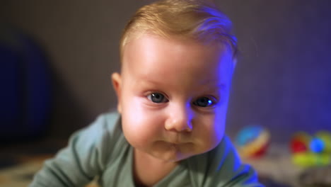 beautiful caucasian big-eyed infant. face of a cute baby looking at camera. close up.