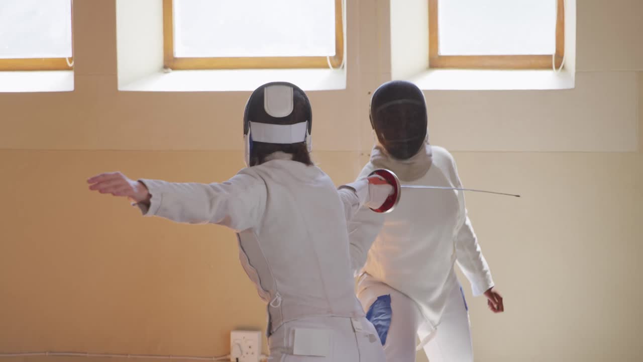 체육관 에서 펜싱 훈련 을 하고 있는 펜싱 선수 들