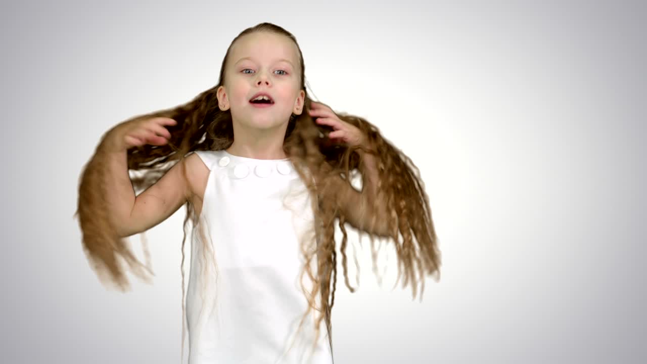 niña pequeña cantando y bailando en fondo blanco