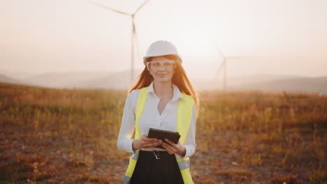 female engineer at wind farm sunset