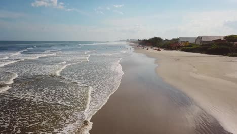 slow rising aerial shot of beach of itanhaem, big clouds and waves in summer