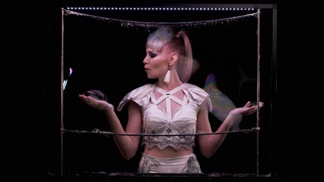 Girl-does-tricks-with-soap-bubbles-She-plays-her-hand-on-soap-wall-on-vertical-frame-with-LED-light