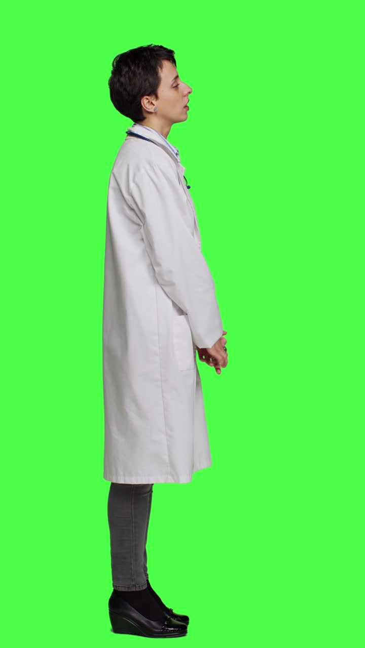 Profilo Medico promettente che giunge le mani in segno di preghiera su green screen