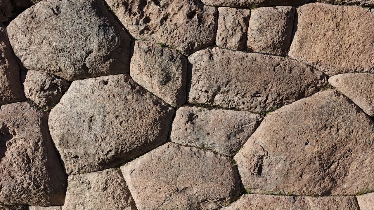 A close-up video showcasing the incredible precision and artistry of a historic Inca wall in Cusco, Peru. The mortar-less, interlocking construction of this ancient civilization's masterful stonework