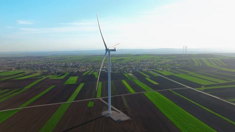 Turbina-Eólica-Girando-Sobre-Exuberantes-Campos-Verdes-Bajo-Un-Cielo-Azul-Claro