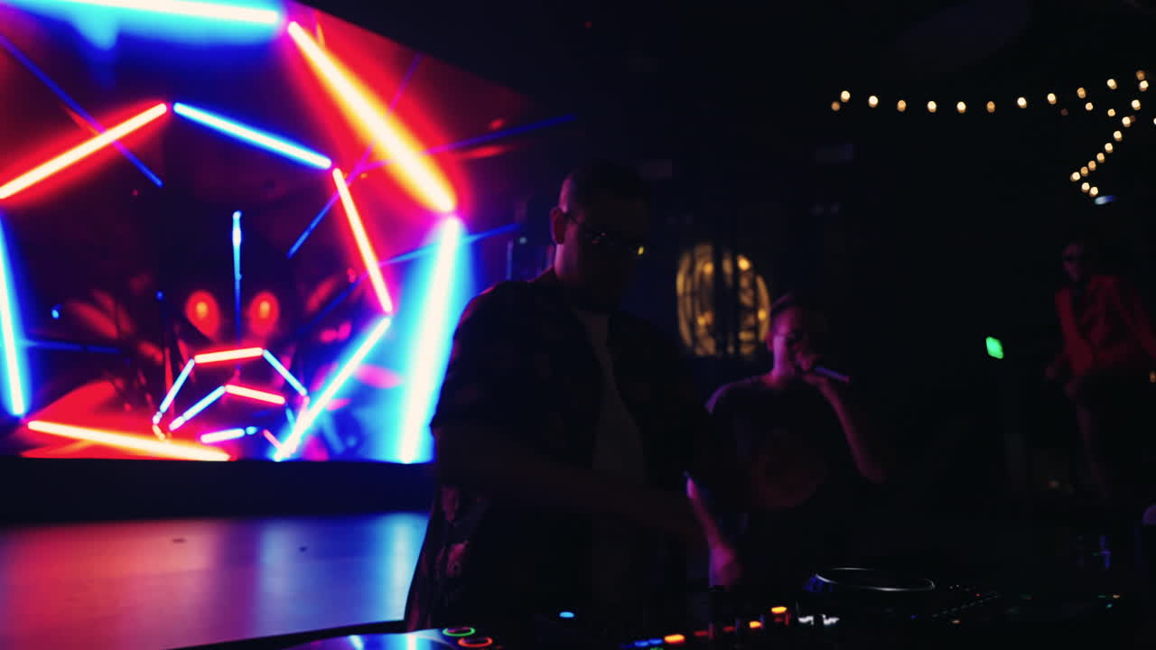 Un DJ qui se produit dans une boîte de nuit.