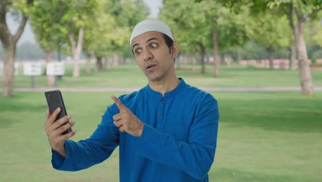 angry muslim man shouting on video call using phone in park