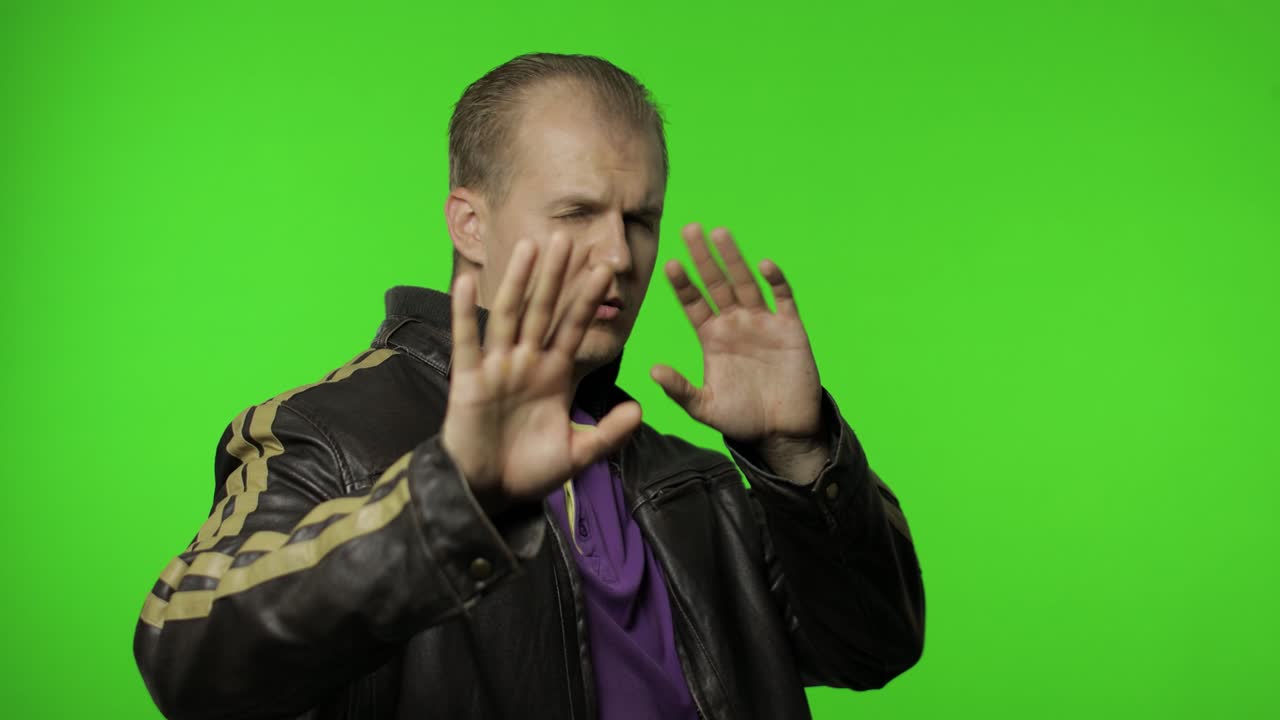 hombre rocker confundido cubriendo los ojos con la mano y mostrando gesto de parada, expresando disgusto por ser visto